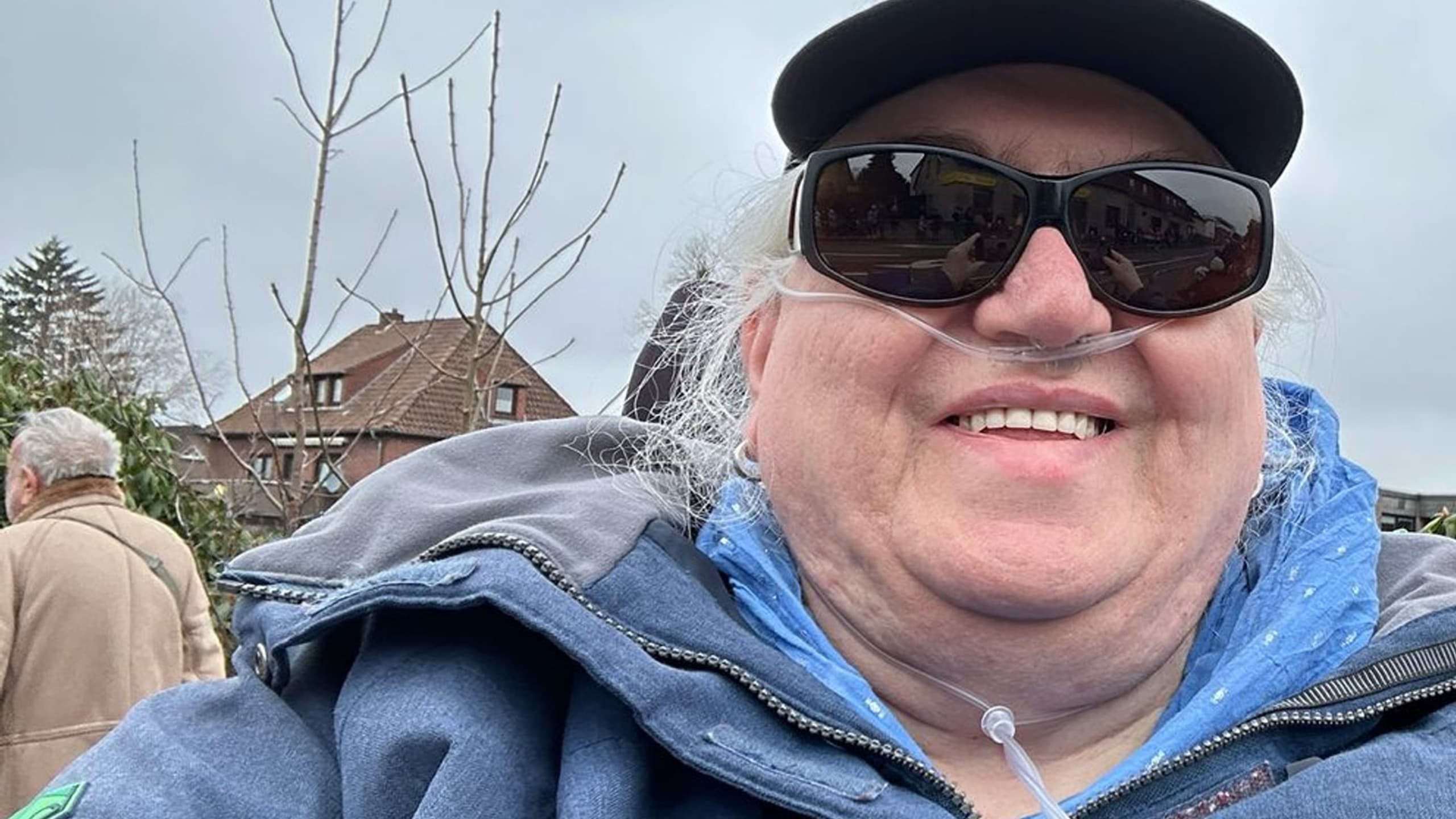 Susanne Steffgen im Freien mit Cap und Blindenabzeichen