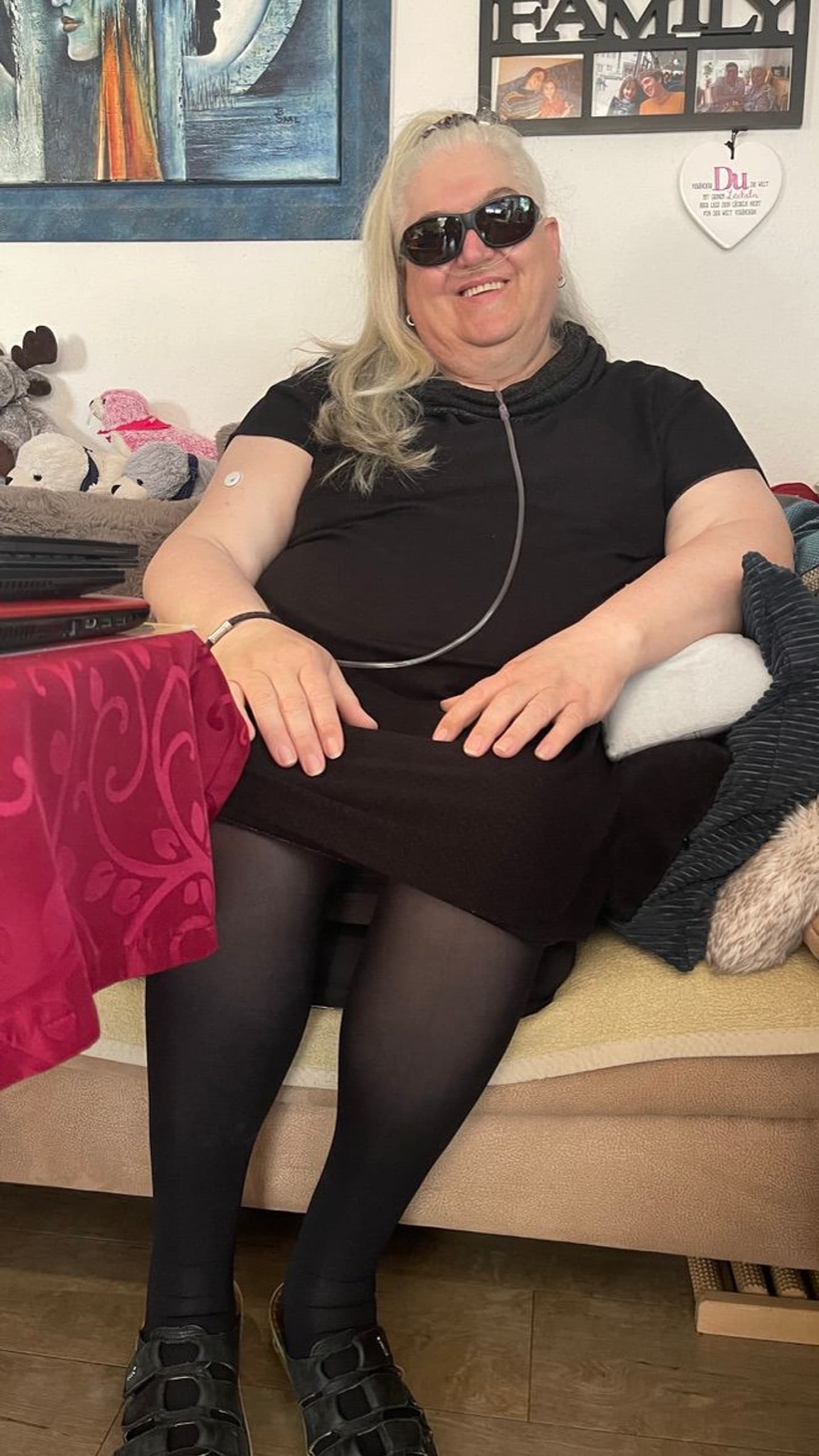 Susanne Steffgen lächelnd zu Hause auf dem Sofa
