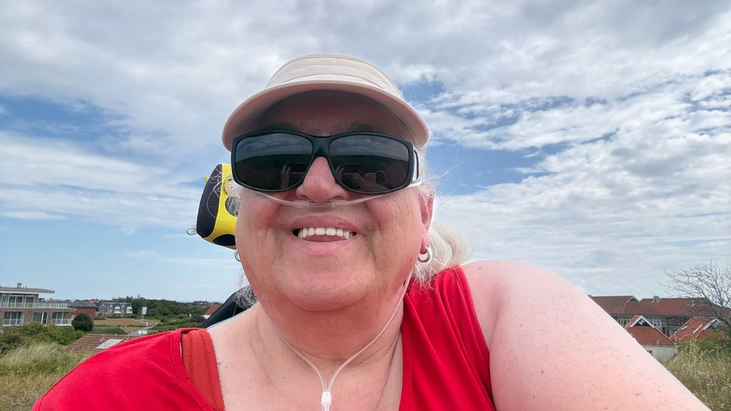 Susanne Steffgen im Freien mit Sonnenschirm Cap und rotem Top